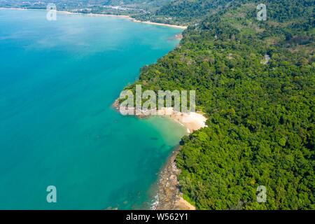Antenne drone Blick auf einen wunderschönen kleinen Sandstrand von üppigen, grünen Nadelwald umgeben Stockfoto