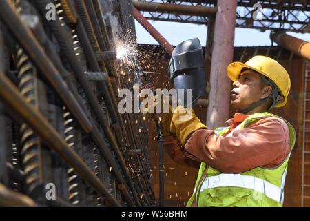 Peking, China's Sichuan Provinz. 26. Juli, 2019. Ein Mitarbeiter arbeitet an einer Baustelle von Lin' Gang der wirtschaftlichen und technologischen Entwicklungszone von Yichang, Provinz Sichuan im Südwesten Chinas, 26. Juli 2019. Trotz der sengenden Hitze, die Arbeitnehmer ihre Beiträge im Freien blockiert den Fortschritt der Projekte zu gewährleisten. Credit: Liu Kun/Xinhua/Alamy leben Nachrichten Stockfoto