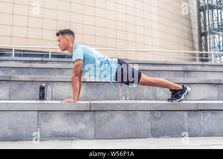 Männlichen Athleten, die im Sommer gut Ausgewrungenen in Stadt, Training Muskeln der Brust und Arme, aktiven Lebensstil, Konzept Gesundheit Sport. Eine Flasche Protein, Gainer Stockfoto