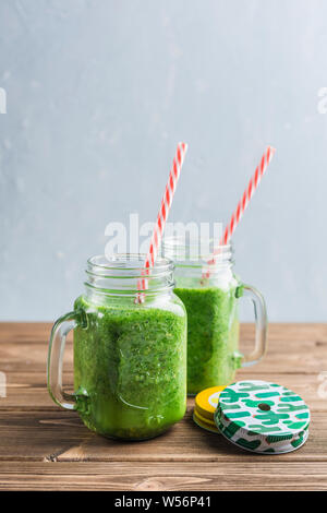 Grüne Smoothie mit Spinat, Apfel, Gurke und Kokosmilch auf Holz- Hintergrund. Der Blick von der Seite. Vegetarische trinken. Gesunde Ernährung. Stockfoto