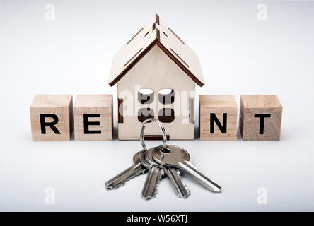 Eine Miniatur Haus mit Holzwürfeln mit Beschriftung mieten und Türschlüssel Stockfoto