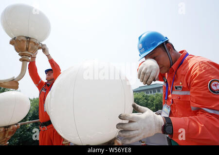 Peking, China. 26. Juli, 2019. Arbeitnehmer Reinigen und Pflegen von straßenlampen in der Chang'an Avenue in Peking, der Hauptstadt von China, 26. Juli 2019. Trotz der sengenden Hitze, die Arbeitnehmer ihre Beiträge im Freien blockiert den Fortschritt der Projekte zu gewährleisten. Credit: Ju Huanzong/Xinhua/Alamy leben Nachrichten Stockfoto