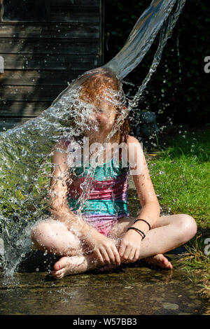 Jugendliche kaukasische Mädchen mit Wasser bespritzt Stockfoto