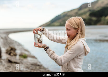 Tween girl Holding ein Aal in Neuseeland Stockfoto