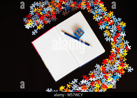 Leeres Buch mit Bleistift und Spitzer nächsten Stücke zu Puzzle. Stockfoto