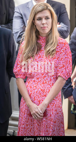Boris Johnson's Freundin Carrie Symonds, in rosa Kleid, wartet draußen 10 Downing Street für die Ankunft des neuen Ministerpräsidenten Stockfoto