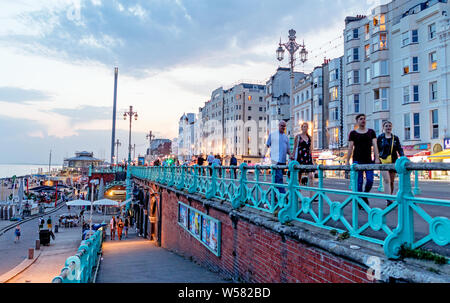 Die Menschen entlang der vorderen bei Dämmerung Brighton UK Bummeln Stockfoto