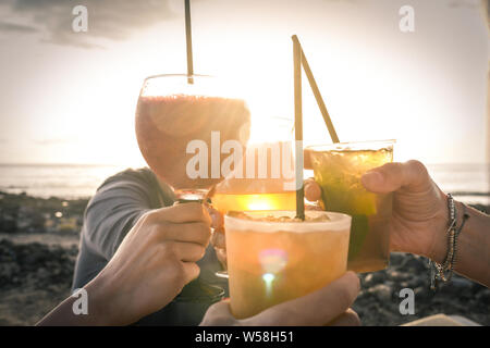 Grüße an die besten Freunde, Freunde genießen Getränke am Abend am Strand bei Sonnenuntergang. Konzept der Ferienhäuser, sorglos, end-of-day Entspannung Stockfoto