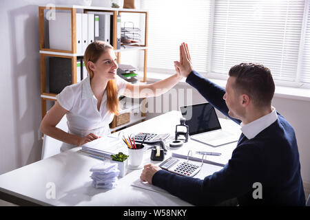 Gerne Unternehmer eine hohe Fünf zu seinen Kollegen im Büro Stockfoto