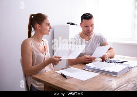 Junge Paare streiten über teure Rechnung zu Hause Stockfoto