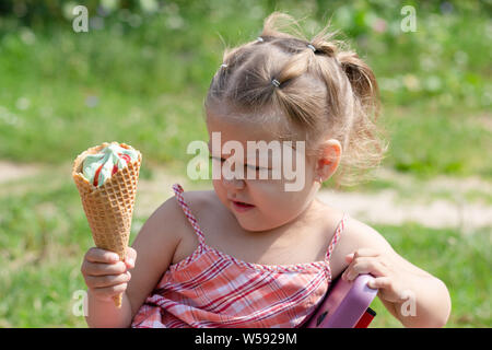 Böse Mädchen auf Waffel Horn von Eis mit fassungslosigkeit im Sommer Park Stockfoto