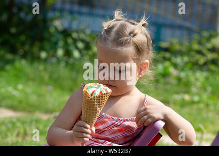 Gerne bisschen Mädchen betrachten Waffel Horn von Eis im Sommer Park Stockfoto