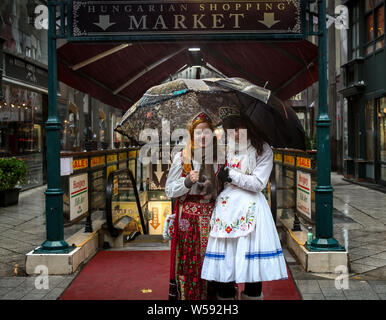 Budapest/Ungarn - 16. Oktober 2013: Zwei junge Mädchen mit traditionellen ungarischen nationalen Kleidung vor der touristischen Güter- Stockfoto