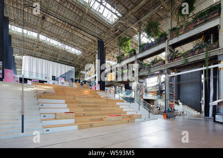 Grosse Treppe vom Erdgeschoss gesehen, mit Sitzgelegenheiten im Vordergrund. Bibliotheek LocHal, Tilburg, Niederlande. Architekt: CIVIC Architekten/Braaksma & Stockfoto