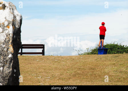 Portland. 26. Juli 2019. UK Wetter. Ein Junge schaut durch ein Teleskop an der Portland Höhen, auf einem anderen Backen - heißen Tag in Dorset. Credit: stuart Hartmut Ost/Alamy leben Nachrichten Stockfoto