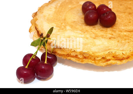 Pfannkuchen zum Frühstück mit Kirschen Beeren isoliert auf weißem Stockfoto