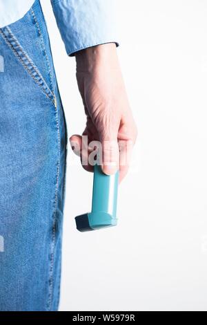 Nahaufnahme einer Hand, die ein Asthma Inhalator. Der Inhaler enthält bronchienerweiternde Medikamente, die verengten Atemwege in der Lunge zu erweitern. Stockfoto