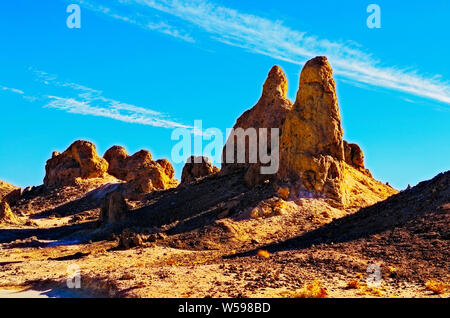 Morgen Sonnenlicht auf hohen Wüste Pinnacles, die lange Schatten auf den Boden unter strahlend blauen Himmel werfen. Stockfoto