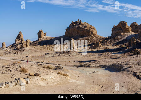 Weg von Felsformationen in öde Wüste. Blauer Himmel, pinnacles Casting Shadows. Stockfoto