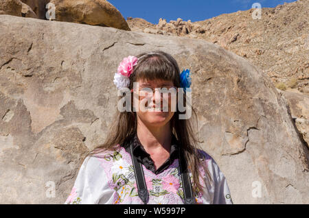 Frauen mit langen braunen Haaren und Blumen im Haar. Stockfoto