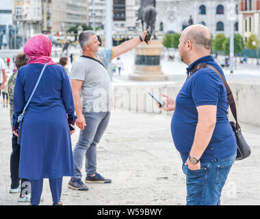 Republik nördlich Skopje, Mazedonien - 27. AUGUST 2018: Touristen fotografieren sich gegenseitig vor dem Museum für Archäologie auf die Steinerne Brücke. Stockfoto