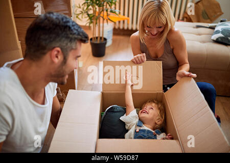 Lustig, Umzug in ein neues Haus - Happy Family bewegt sich in einem neuen Haus Stockfoto