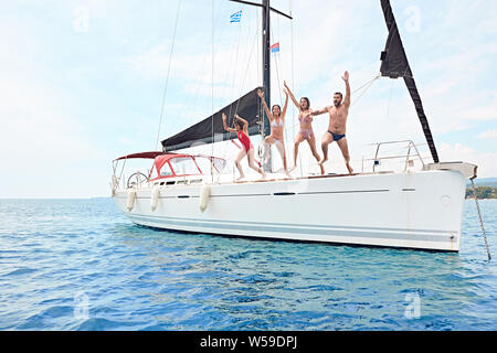 Jungen Freunden rumhängen, Spaß haben und genießen Sie die sommertage Sprung vom Segelboot in See. Stockfoto