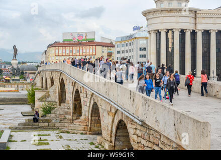 Republik nördlich Skopje, Mazedonien - 27. AUGUST 2018: Fußgänger überqueren der Steinbrücke über den Fluss Vardar von Osten nach Westen, und aus dem Alten cit Stockfoto