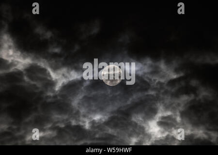 Die Juli 2019 Vollmond als durch Wolken von Wake Forest, North Carolina, USA. Stockfoto