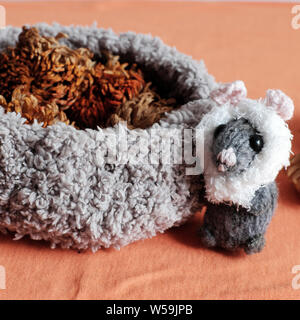 Nette Mäuse stehen in der Nähe von Korb von getrockneten Blumen auf orangem Hintergrund, Wolle kleine Ratte stricken aus Garnen in der freien Zeit der Handwerkskunst Stockfoto