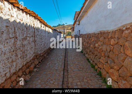 Straße in der Stadt Chinchero am Morgen mit Inca style Wand Architektur, Kopfsteinpflaster und Wasser Kanal, Cusco Region, Peru. Stockfoto