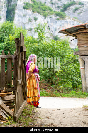 Pinarbasi, Kastamonu/Turkey-June 29 2019: Lokale türkische Frau in traditionelle bunte Kleidung von Gartentor. Stockfoto