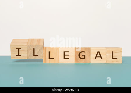 Schlagen Zwei hölzerne Würfel das Wort Legal zu Illegalen auf neutralem Hintergrund zu ändern. Stockfoto