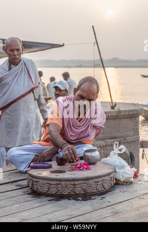 Ein Guru der Durchführung einer hinduistischen Zeremonie zu lokalen Pilger an der Ganges in Varanasi bei Sonnenaufgang. Stockfoto