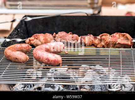 Köstliches Fleisch und Bayerische Wurst auf dem Grill. Stockfoto