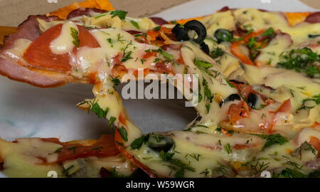 Jagd Pizza mit Wurst, Rindfleisch, Tomaten und Oliven auf den Tisch. Stockfoto