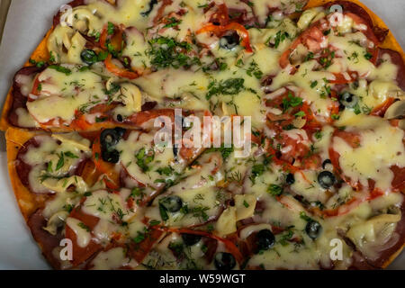 Jagd Pizza mit Wurst, Rindfleisch, Tomaten und Oliven auf den Tisch. Stockfoto