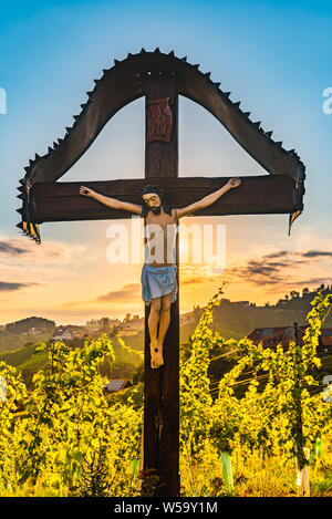 Christian Holzkreuz mit Abbildung von Jesus Christus auf Weinberge an Slowenien - Österreich Grenze in der Nähe von berühmten touristischen Ziel der herzförmigen Straße. Stockfoto