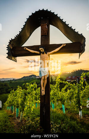 Christian Holzkreuz mit Abbildung von Jesus Christus auf Weinberge an Slowenien - Österreich Grenze in der Nähe von berühmten touristischen Ziel der herzförmigen Straße. Stockfoto