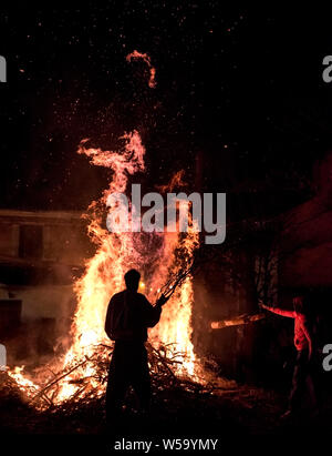 Die Menschen feiern St John's Eve um ein Lagerfeuer in einem griechischen Dorf Stockfoto