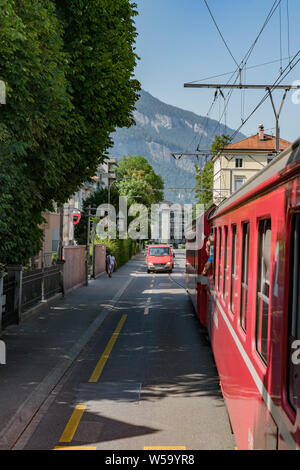 Chur, GR/Schweiz - 24. Juli, 2019: rot Rhatian Eisenbahn Zug stoppt Verkehr wie fährt er auf den Straßen der Innenstadt von Chur Stockfoto