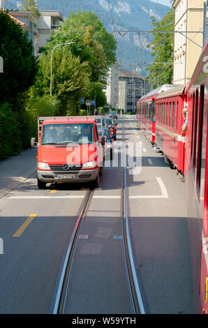 Arosa, GR/Schweiz - 24. Juli, 2019: rot Rhatian Eisenbahn Zug stoppt Verkehr wie fährt er auf den Straßen der Innenstadt von Chur Stockfoto