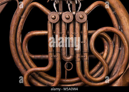 Vintage Bronze Rohre, Ventil, Schlüssel mechanische Elemente Horn auf schwarzem Hintergrund isoliert. Gutes Muster, prompt Musik Instrument. Stockfoto