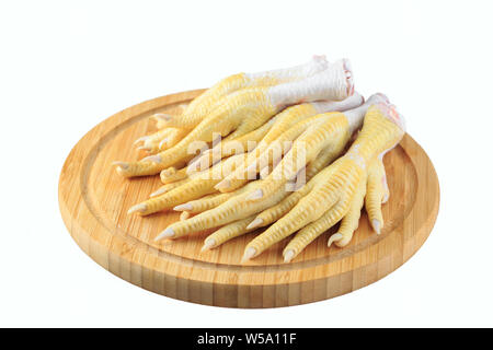 Huhn Füße auf einem weißen Hintergrund auf einem Holzbrett Stockfoto