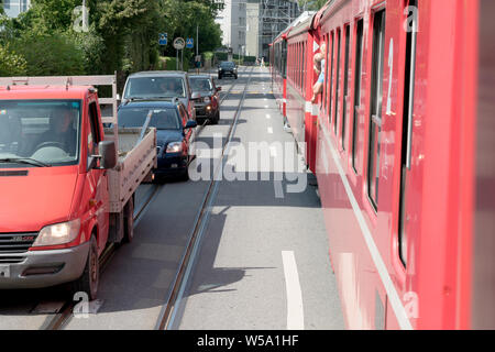 Arosa, GR/Schweiz - 24. Juli, 2019: rot Rhatian Eisenbahn Zug stoppt Verkehr wie fährt er auf den Straßen der Innenstadt von Chur Stockfoto