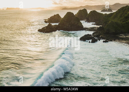 Sunset Landschaft mit riesigen Wellen und Hügel am Horizont. Insel Lombok, Indonesien Stockfoto