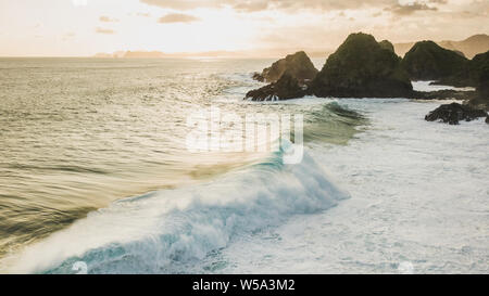 Sunset Landschaft mit riesigen Wellen und Hügel am Horizont. Insel Lombok, Indonesien Stockfoto