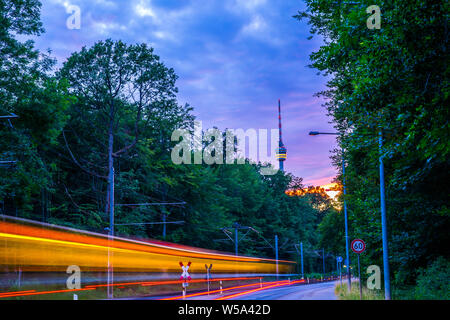 Deutschland, leuchtenden Lampen von Straßenbahn und Fernsehturm Stuttgart Stadt im Wald im magischen anbrechenden Dämmerung Stimmung nach Sonnenuntergang im Sommer Stockfoto