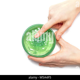 Aloe Vera Gel auf Eine weibliche Hand, die es Schaufeln ist aus einem jar auf weißem Hintergrund, oben auf Ansicht. Aloe Vera ist natürliches Heilmittel für Sonnenbrand Erleichterung. Stockfoto