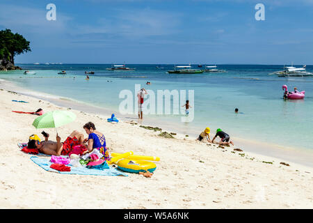 Eine Familie entspannt auf Alona Beach, Bohol, Philippinen Stockfoto